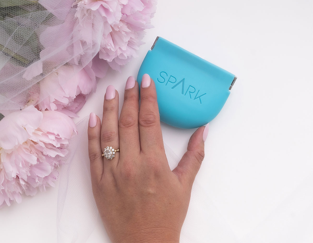 Woman's hand holding Spark Clear Aligner blue box