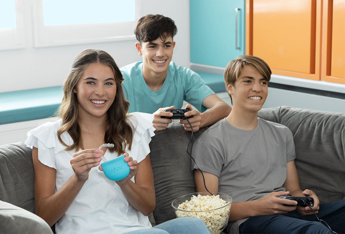 Teenagers laughing and holding Spark Clear Aligner box